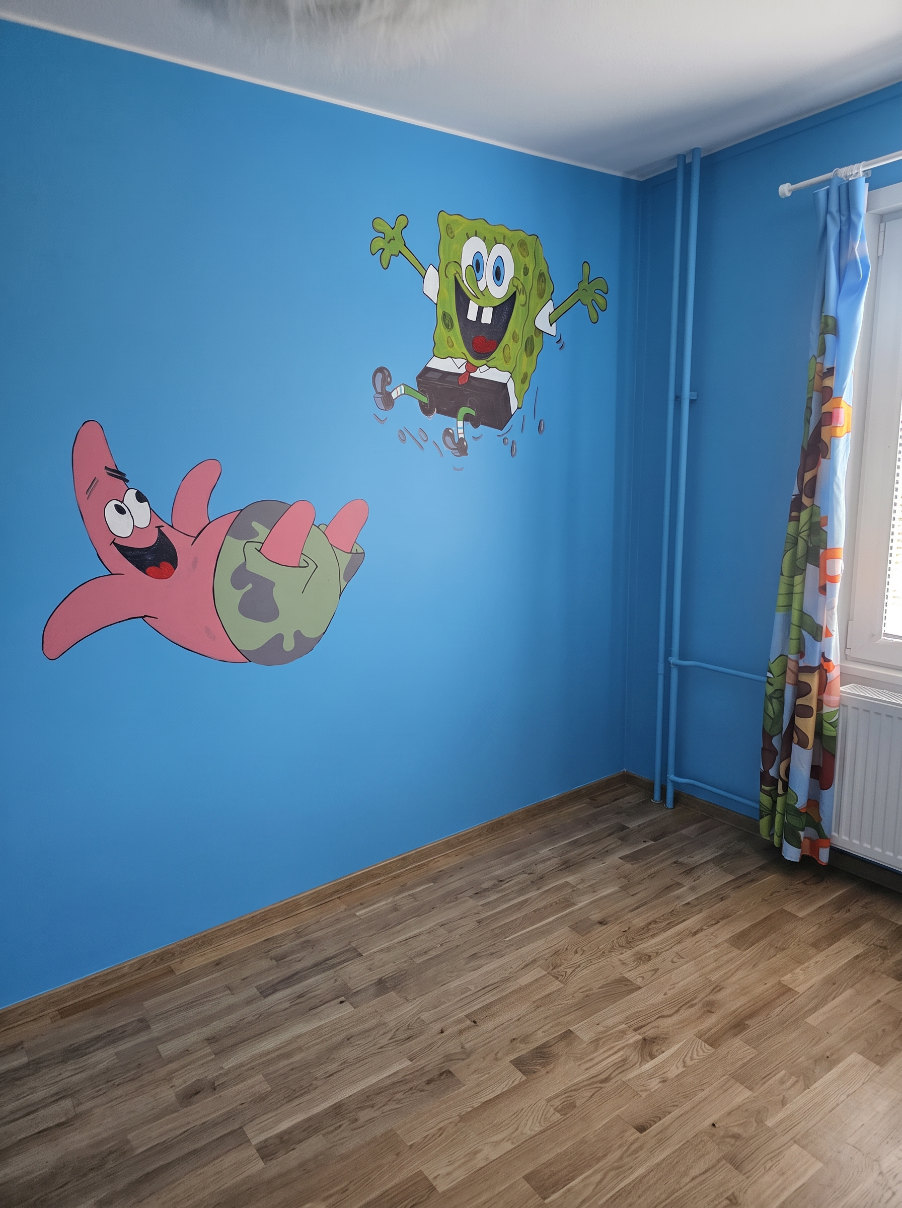 Handmålade Svampbob och Patrick på blå vägg i barnrum